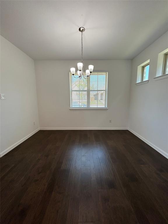 1448 Sun Gdn Way Justin, TX 76247 - Photo 6 of 28 Unfurnished room with suspended lighting and dark wood-style floors