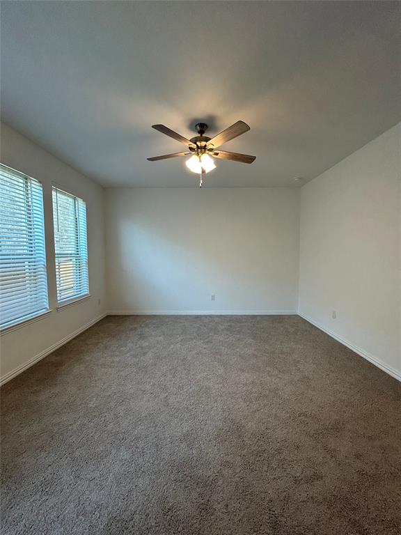 1448 Sun Gdn Way Justin, TX 76247 - Photo 8 of 28 Empty room featuring dark carpet and ceiling fan