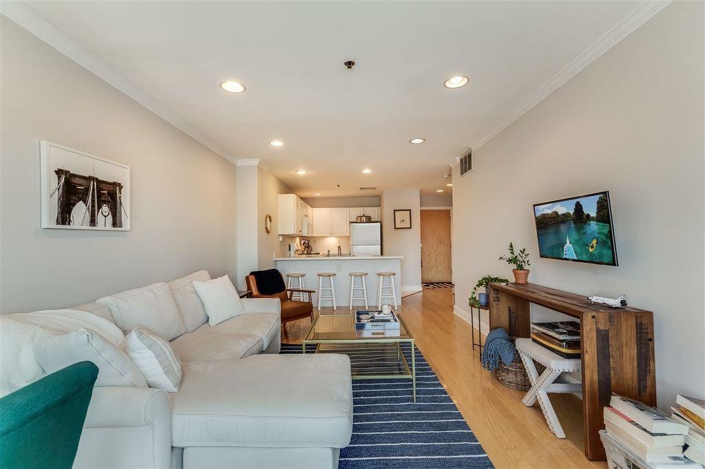711 Clinton Street, Unit 6A Hoboken, NJ 07030 - Photo 5 of 15 a living room with furniture and a flat screen tv
