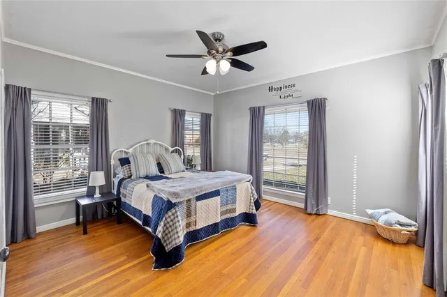 a bed sitting in a spacious bedroom next to a window