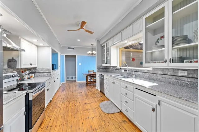 a large kitchen with kitchen island a large counter space a sink stainless steel appliances and cabinets