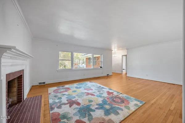 an empty room with windows and fireplace