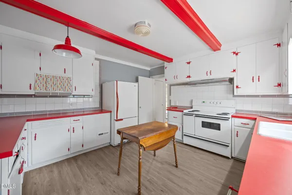 a kitchen with a sink cabinets and wooden floor