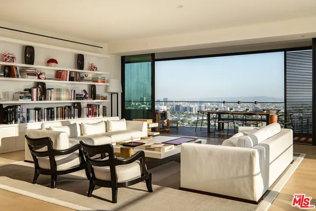a living room with furniture kitchen view and large window