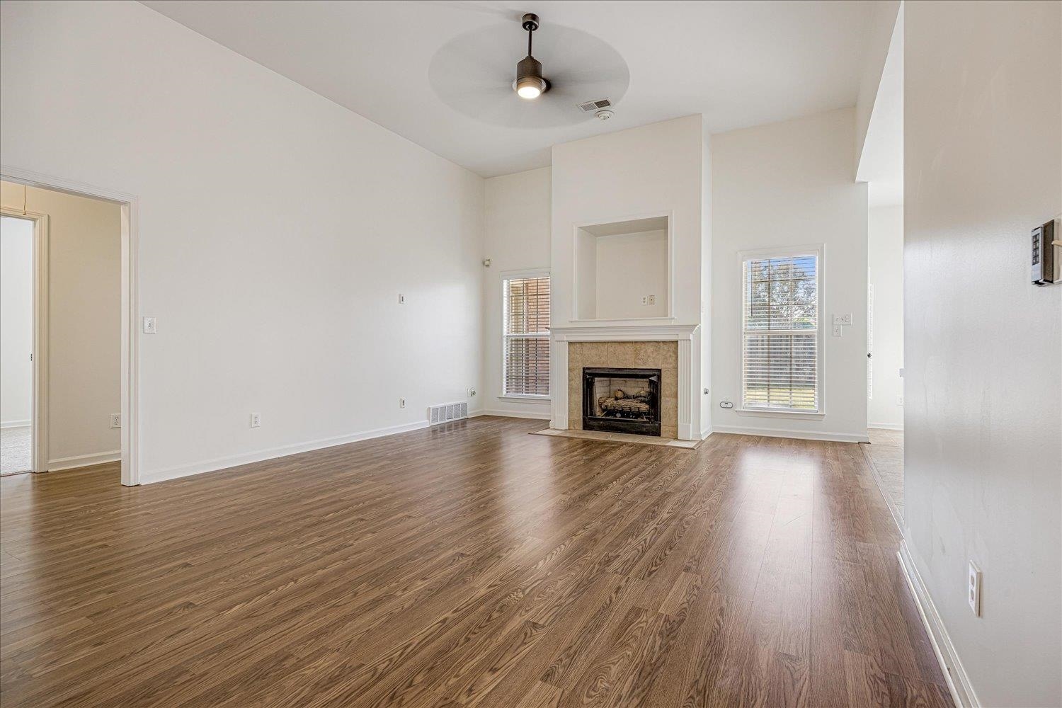 8453 Thor Road Memphis, TN 38018 - Photo 7 of 29 a view of an empty room with wooden floor fireplace and a window