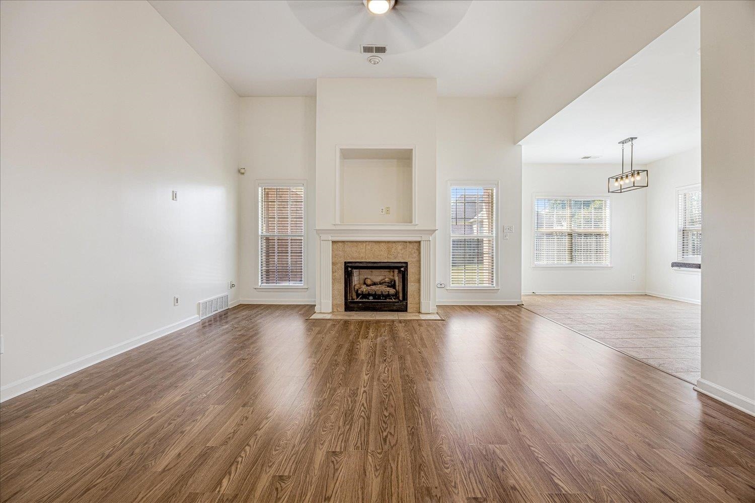 8453 Thor Road Memphis, TN 38018 - Photo 8 of 29 an empty room with wooden floor fireplace and windows
