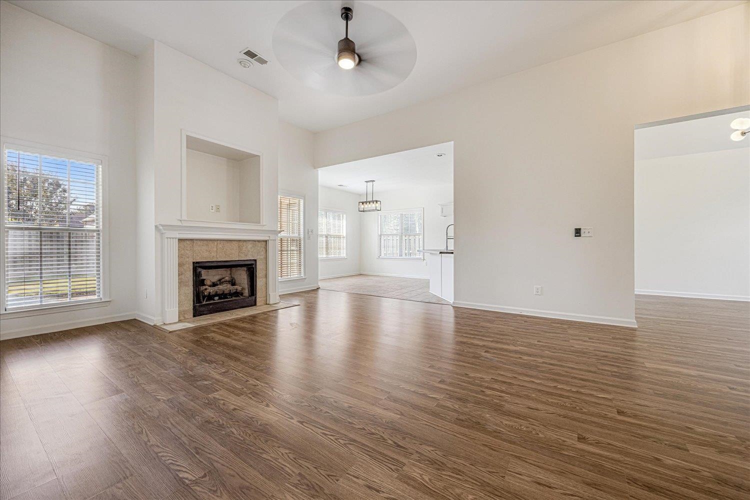 8453 Thor Road Memphis, TN 38018 - Photo 9 of 29 an empty room with wooden floor fireplace and windows