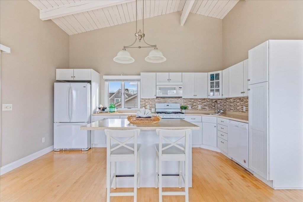 8 Feake Avenue Sandwich, MA 02563 - Photo 5 of 34 a kitchen with stainless steel appliances granite countertop a refrigerator a stove and white cabinets with wooden floor