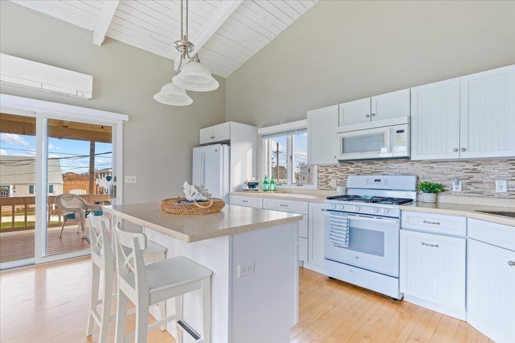 8 Feake Avenue Sandwich, MA 02563 - Photo 7 of 34 a kitchen with stainless steel appliances granite countertop a stove a sink dishwasher and white cabinets with wooden floor