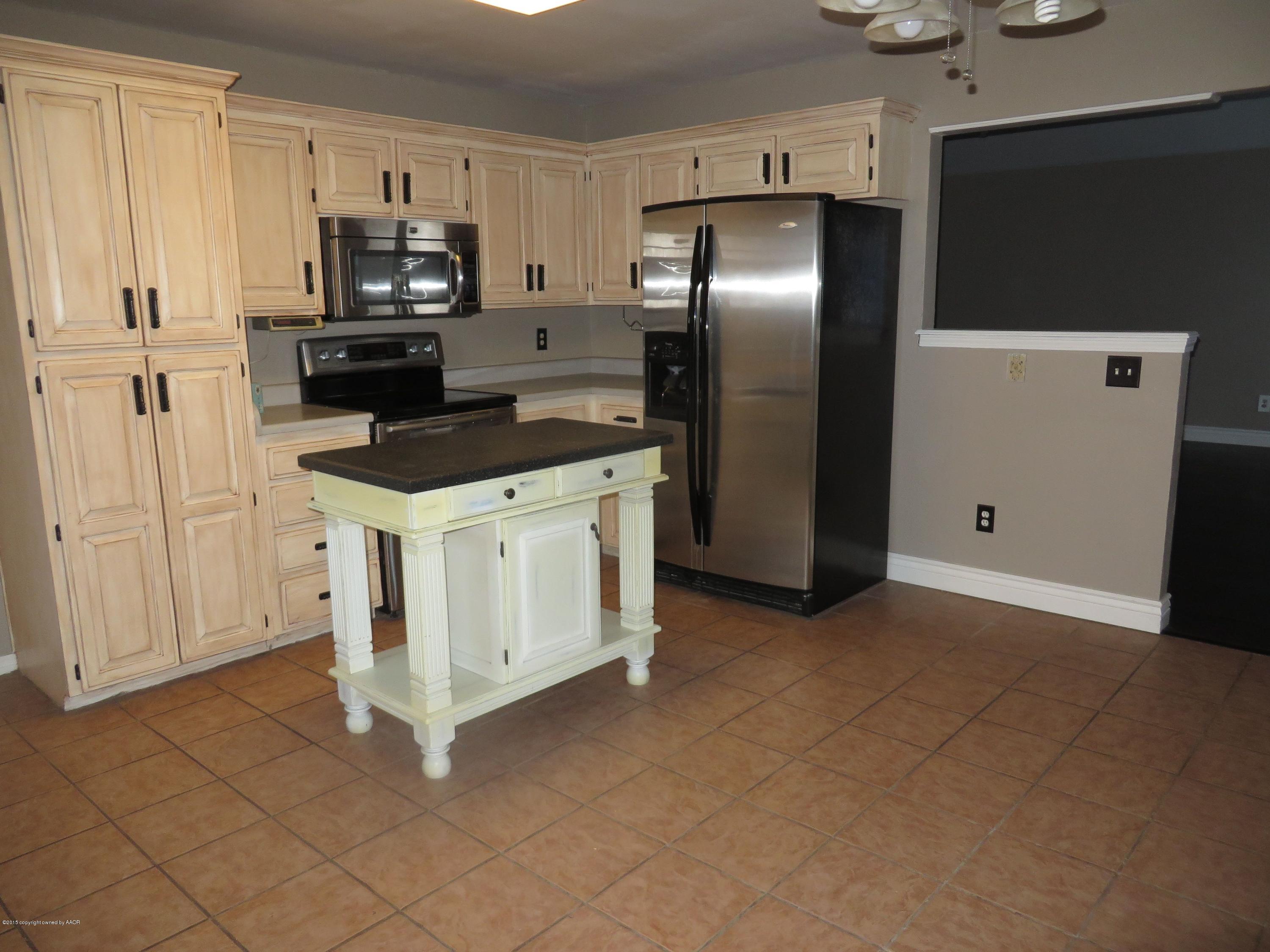 4213 Rincon Avenue Amarillo, TX 79110 - Photo 3 of 9 a kitchen with stainless steel appliances a refrigerator stove and microwave