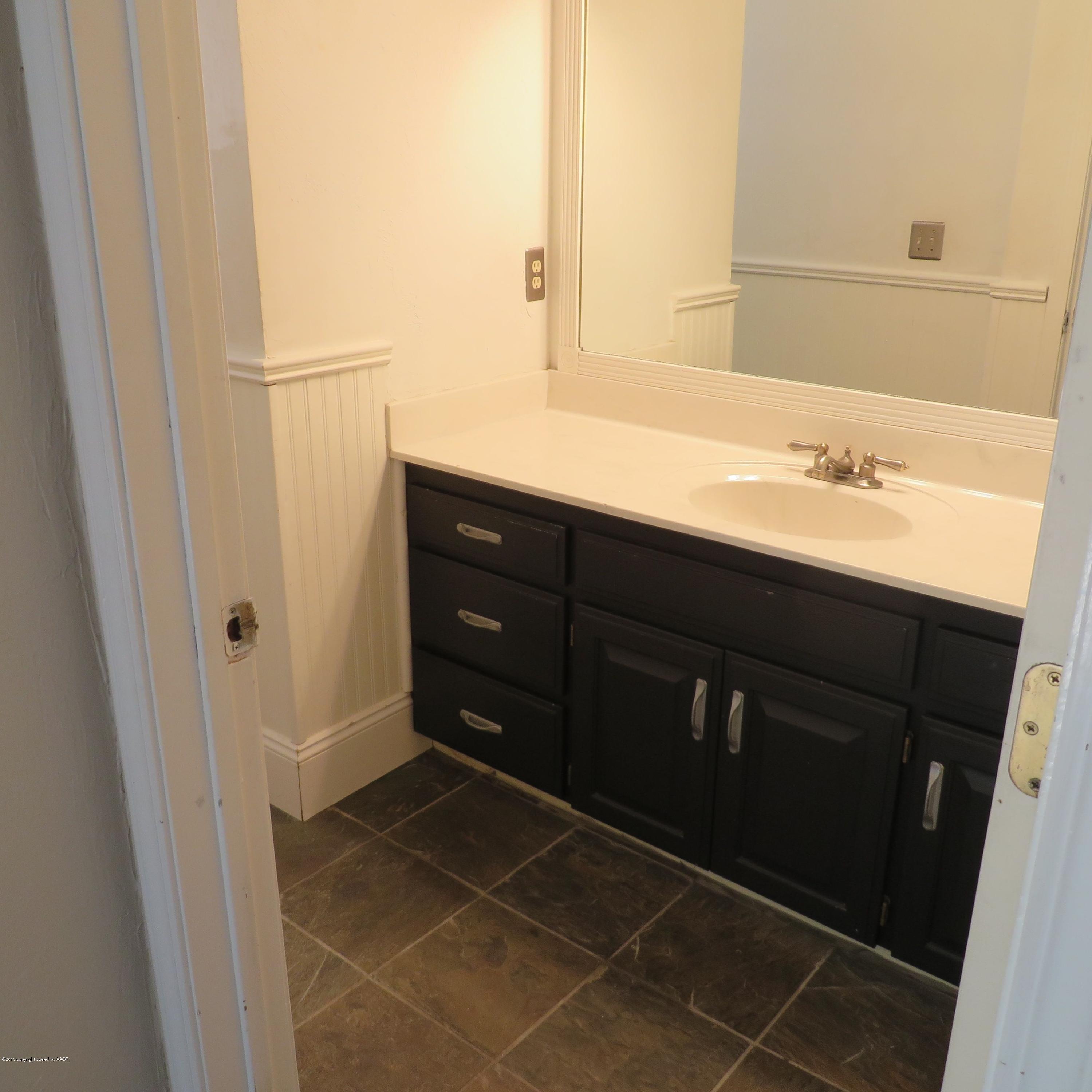 4213 Rincon Avenue Amarillo, TX 79110 - Photo 9 of 9 a bathroom with a sink and a mirror