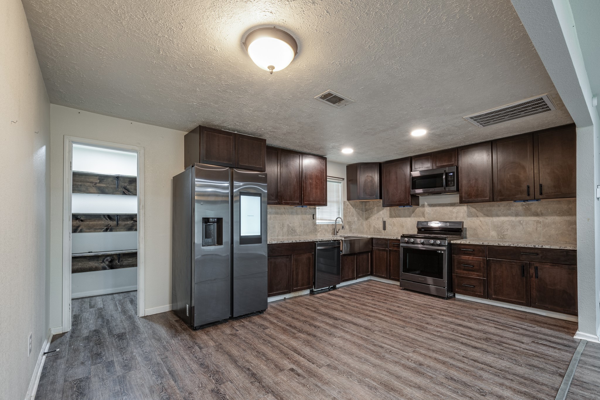 248 Fm-770 Liberty, TX 77575 - Photo 8 of 30 a kitchen with stainless steel appliances kitchen island granite countertop a refrigerator stove and oven