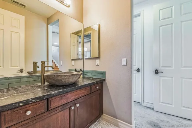 a bathroom with a granite countertop sink and a mirror