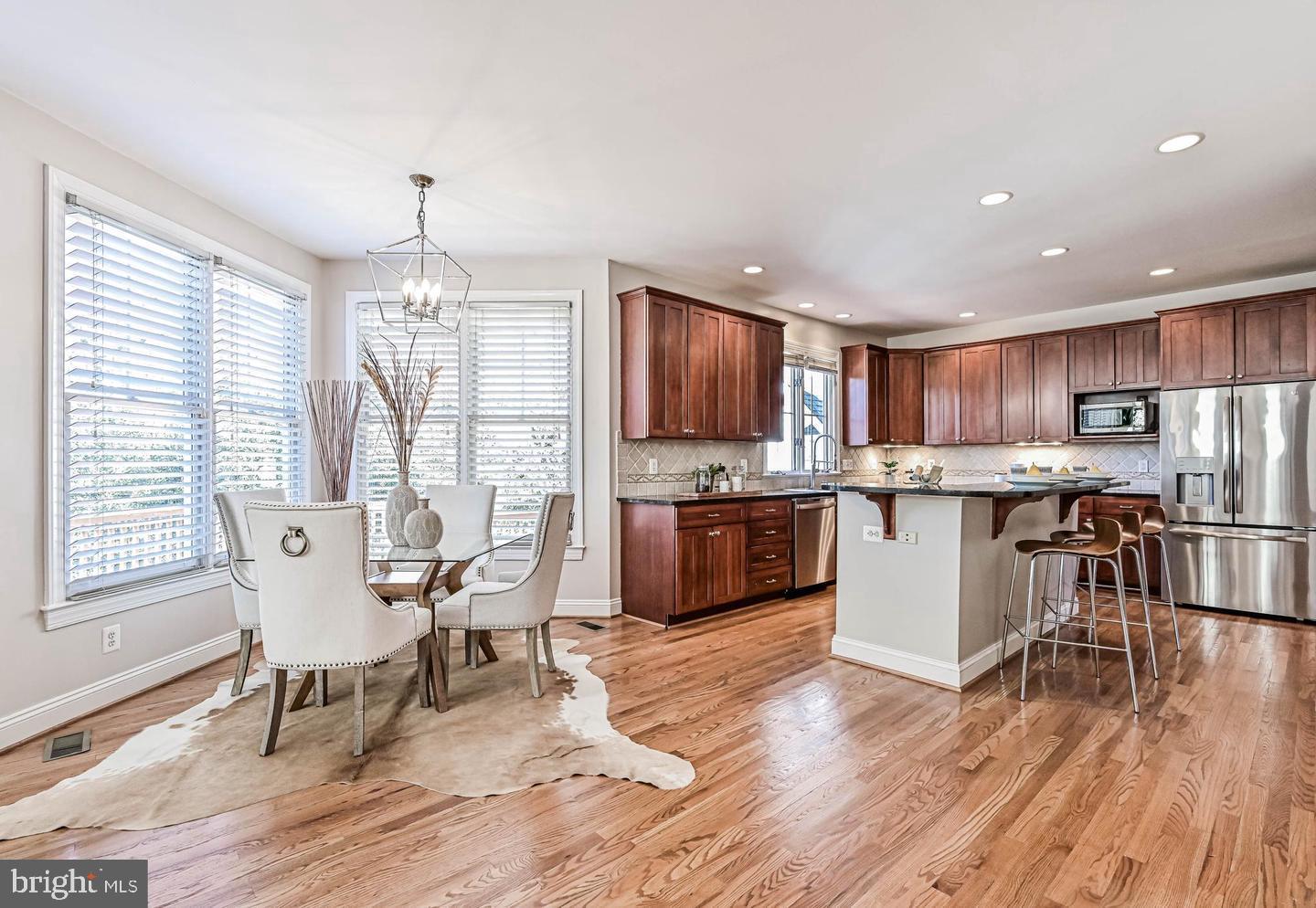 6516 76th Place Cabin John, MD 20818 - Photo 12 of 46 a living room with stainless steel appliances kitchen island granite countertop wooden floor a dining table and chairs