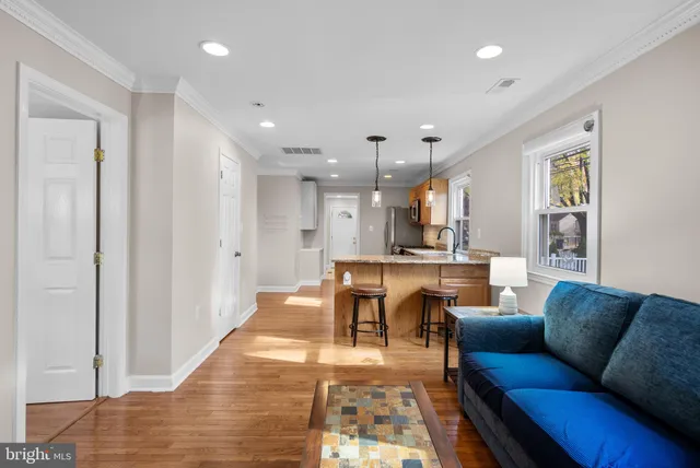 a living room with furniture and a dining table with kitchen view