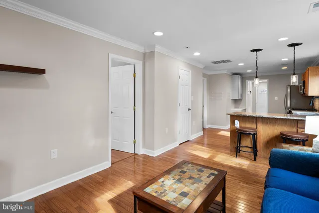a living room with kitchen island furniture and a wooden floor