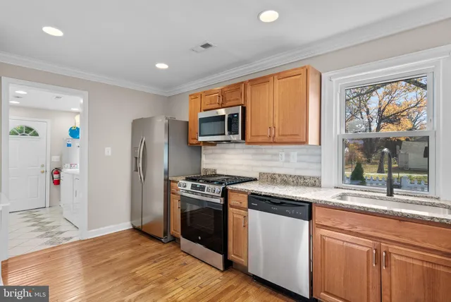 a kitchen with stainless steel appliances granite countertop a stove a sink and a refrigerator