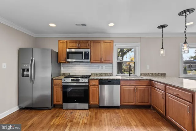 a kitchen with stainless steel appliances granite countertop a stove a sink and a refrigerator