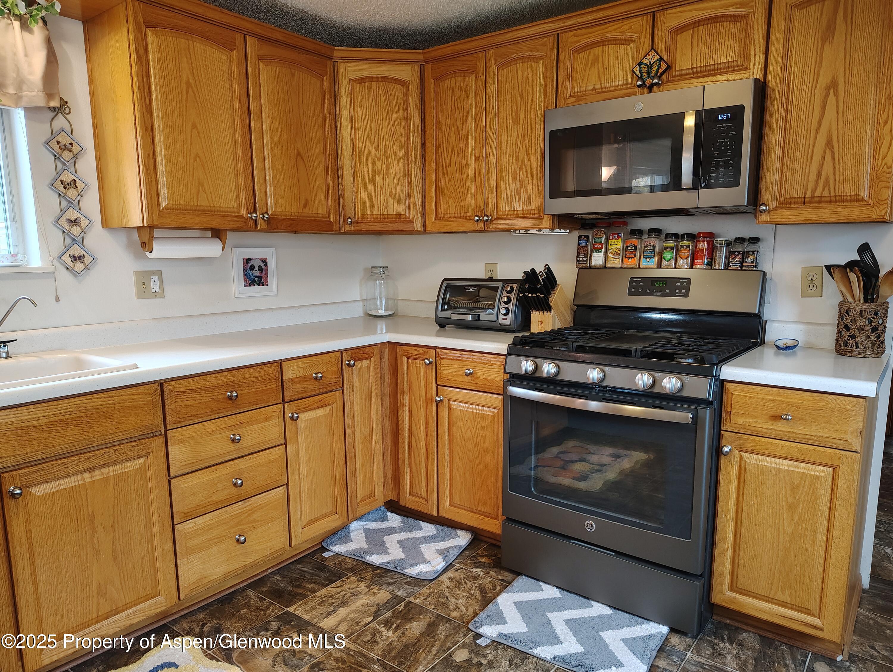 8 St John Circle Parachute, CO 81635 - Photo 13 of 32 a kitchen with stainless steel appliances granite countertop a stove a sink and a microwave