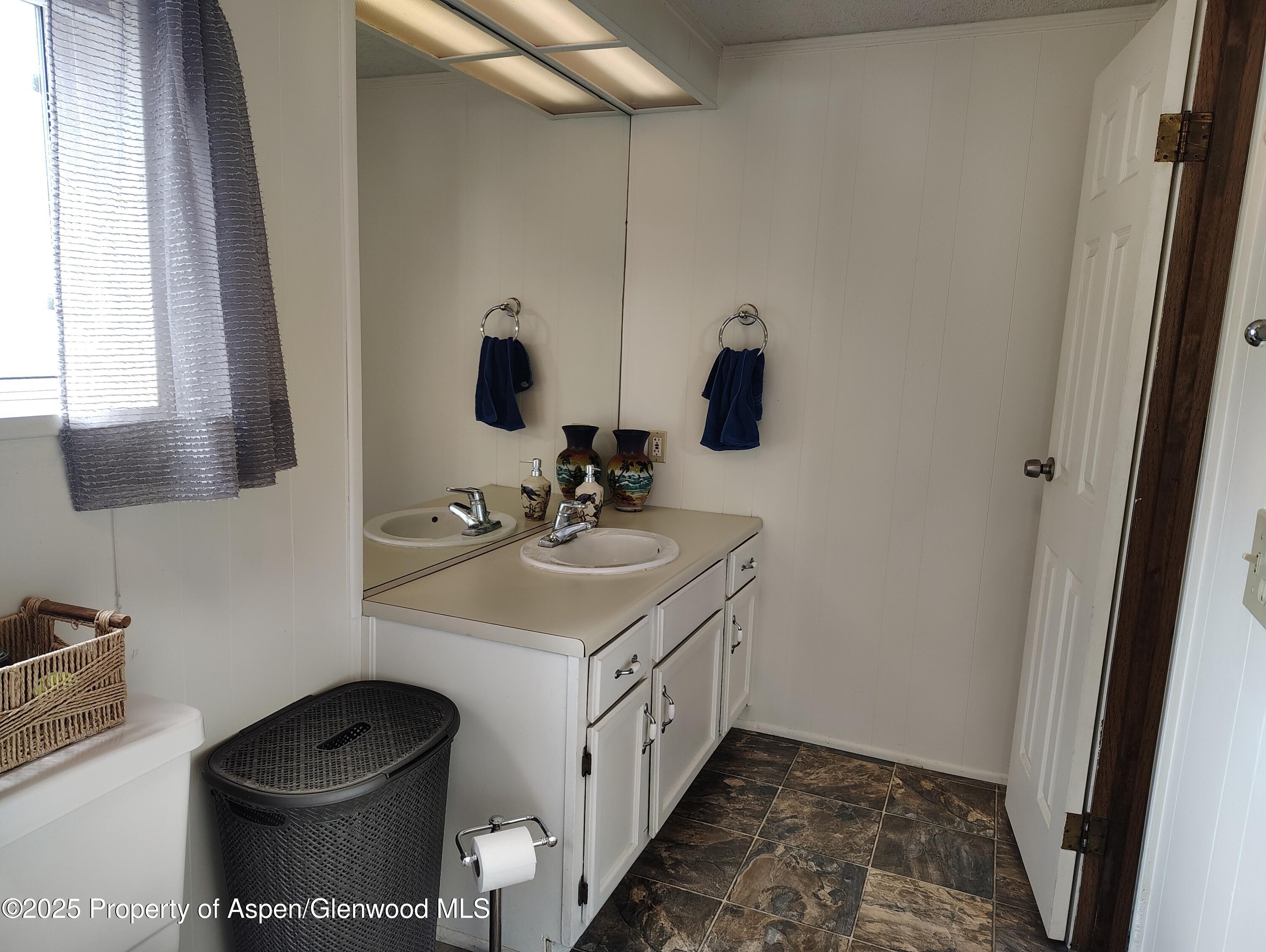 8 St John Circle Parachute, CO 81635 - Photo 20 of 32 a bathroom with a double vanity sink and mirror