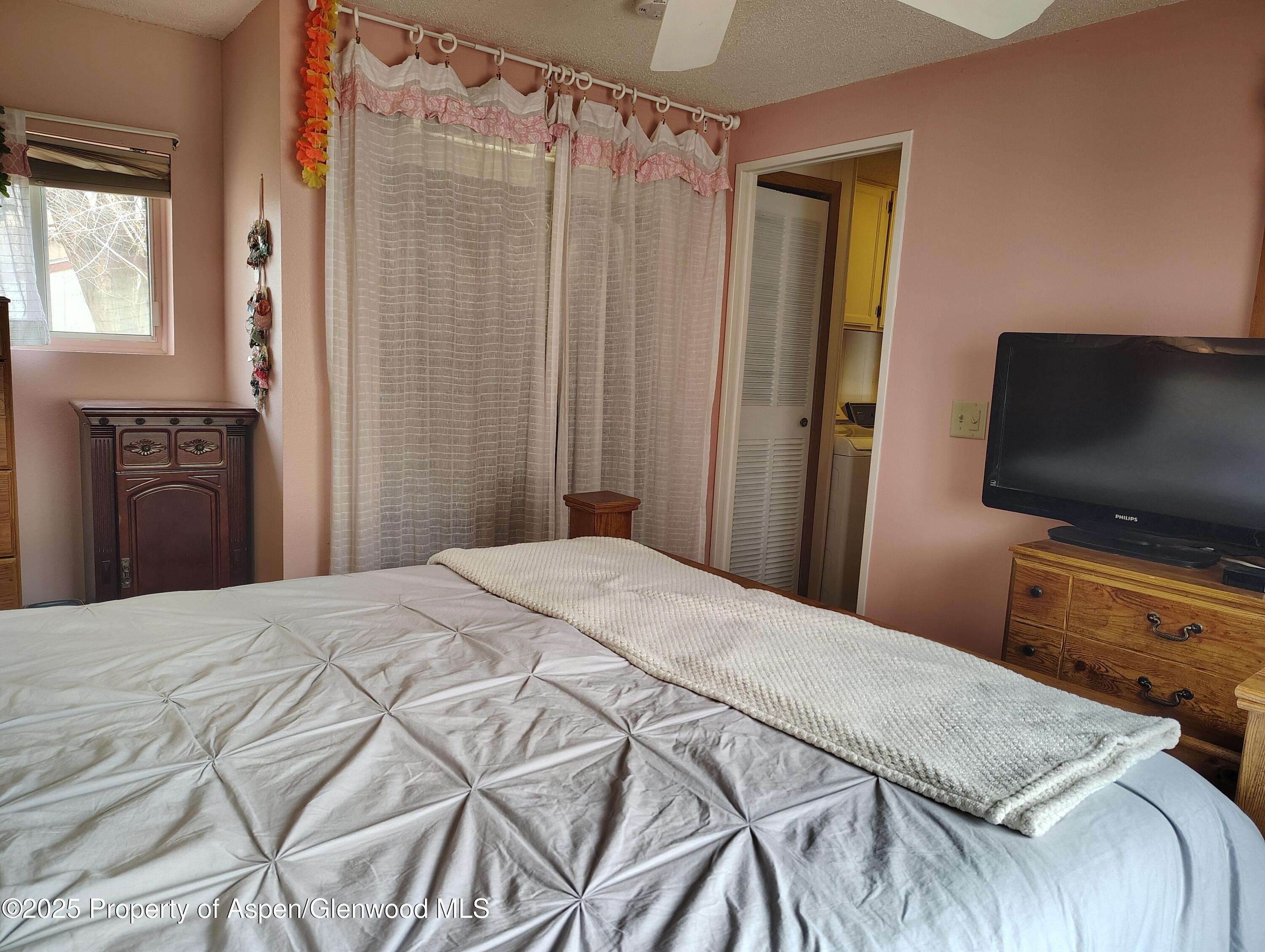 8 St John Circle Parachute, CO 81635 - Photo 22 of 32 a bedroom with a bed and a flat tv screen on wall
