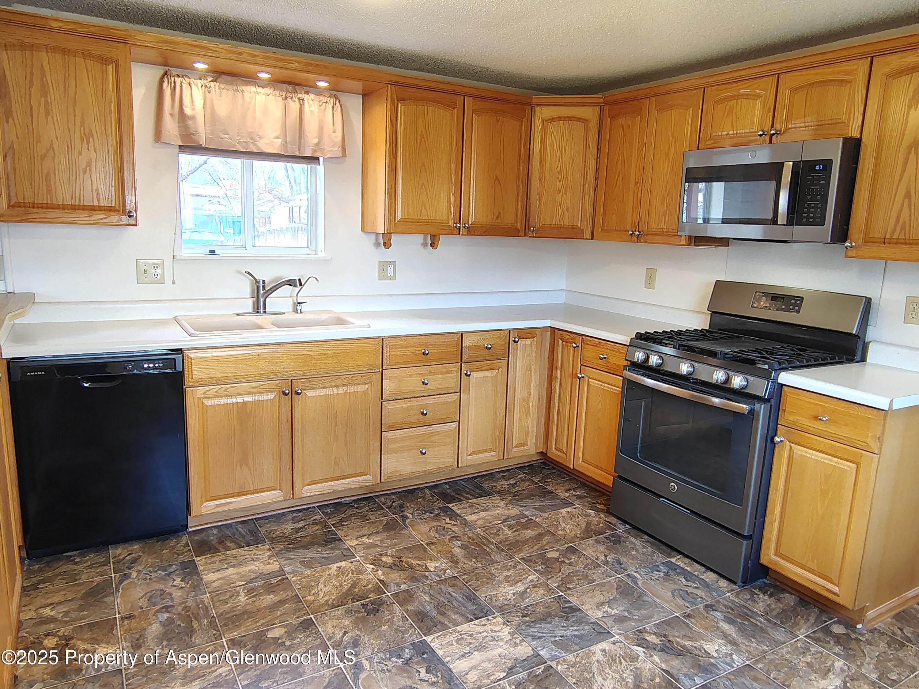 8 St John Circle Parachute, CO 81635 - Photo 6 of 32 a kitchen with stainless steel appliances granite countertop a stove sink microwave and window