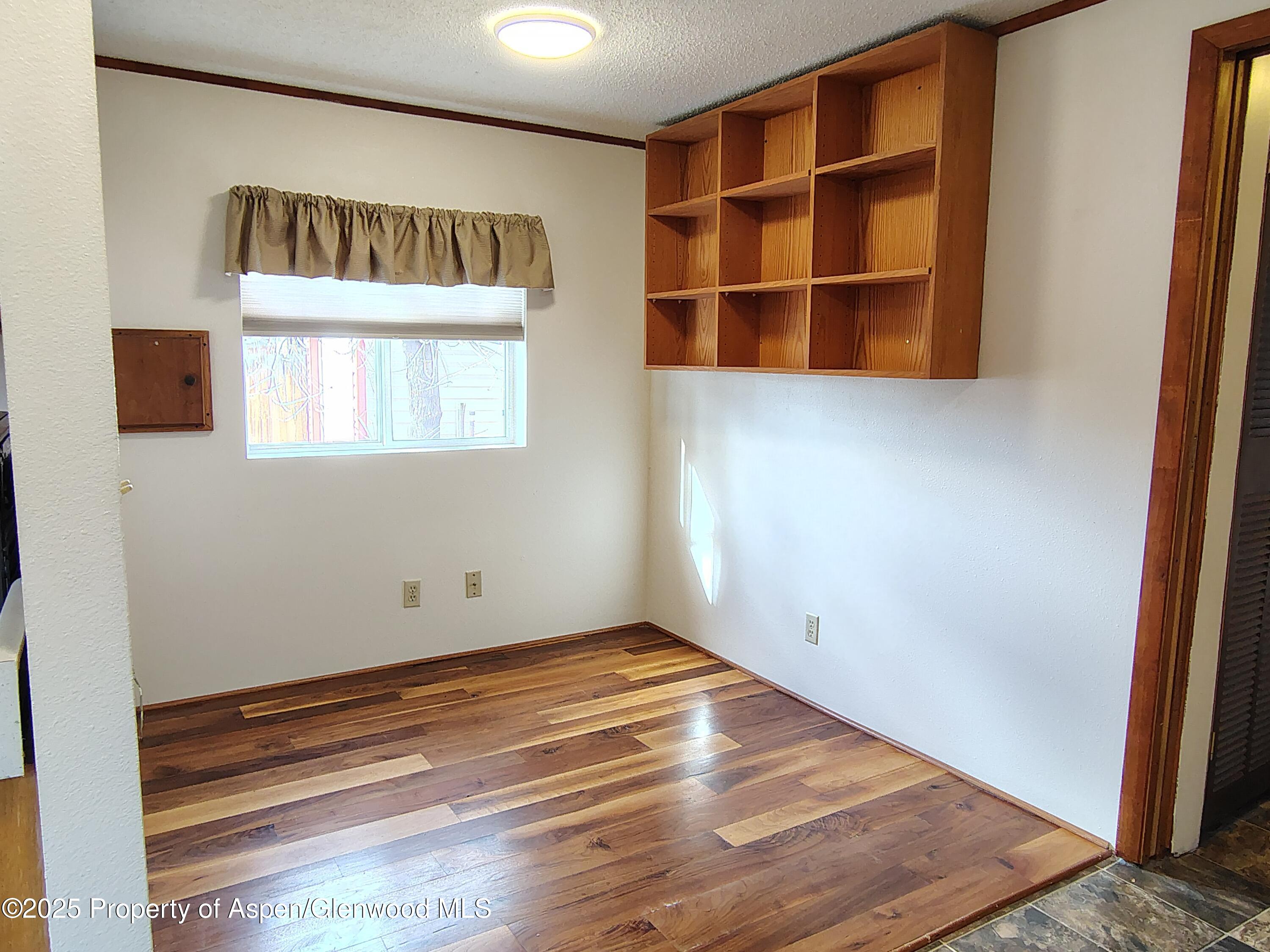8 St John Circle Parachute, CO 81635 - Photo 9 of 32 a view of an empty room with wooden floor and windows