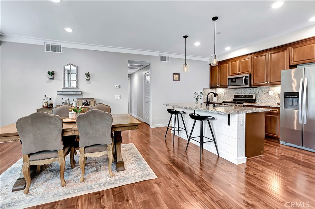 a view of a dining room with furniture a rug and wooden floor