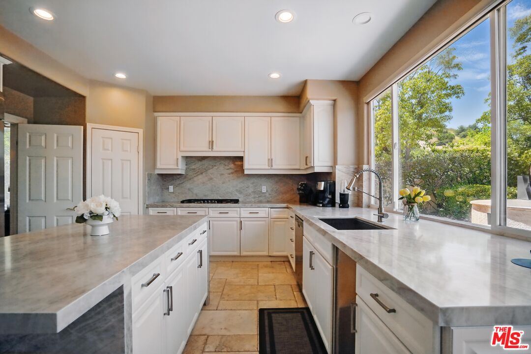 4040 Leighton Point Road Calabasas, CA 91301 - Photo 13 of 47 a kitchen with a sink stove and cabinets