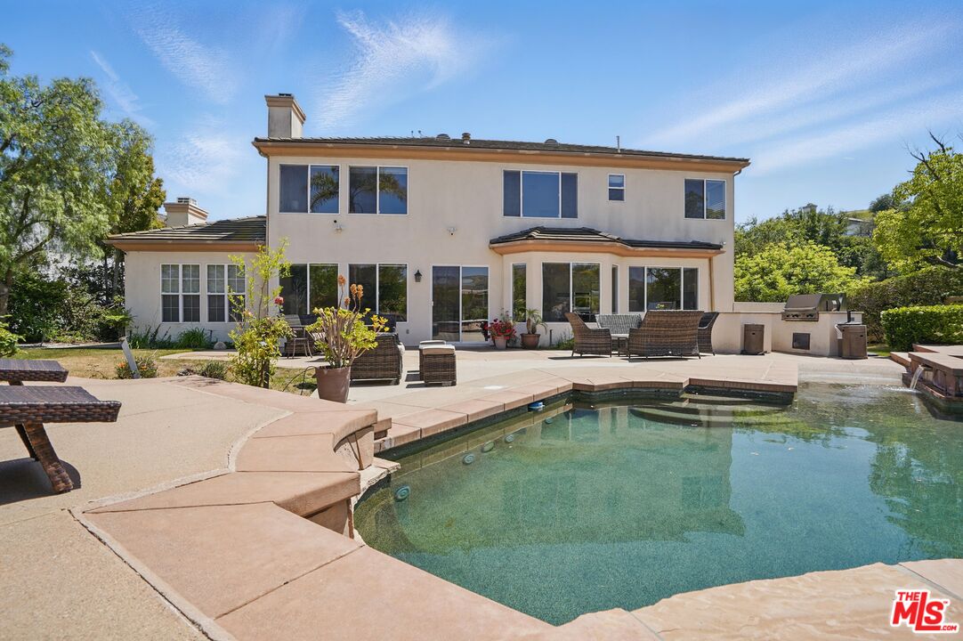 4040 Leighton Point Road Calabasas, CA 91301 - Photo 21 of 47 a swimming pool view with a seating space and a garden