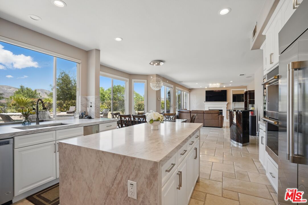 4040 Leighton Point Road Calabasas, CA 91301 - Photo 3 of 47 a large kitchen with granite countertop a large counter top stainless steel appliances a sink and cabinets