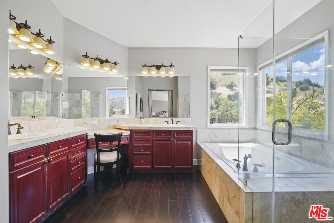 4040 Leighton Point Road Calabasas, CA 91301 - Photo 36 of 47 a large bathroom with a granite countertop tub a double vanity sink a window and a mirror