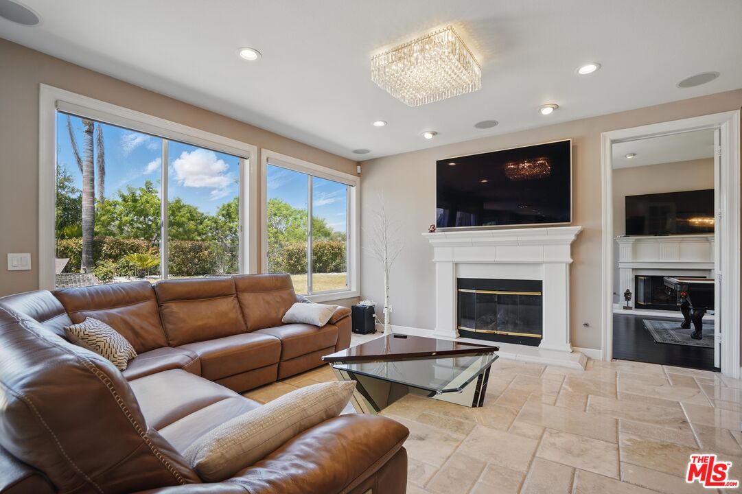 4040 Leighton Point Road Calabasas, CA 91301 - Photo 7 of 47 a living room with furniture a flat screen tv and a fireplace