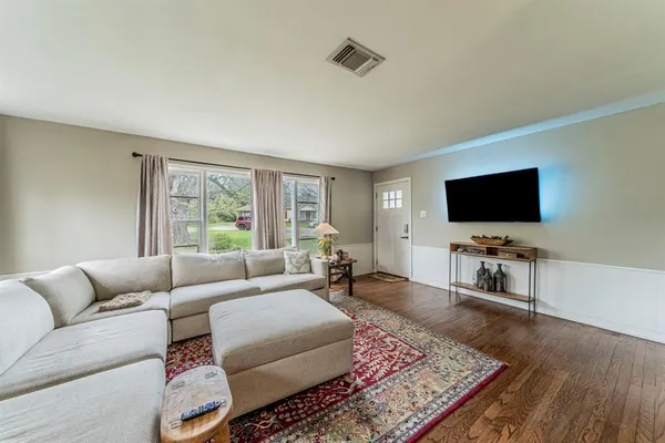 a view of a livingroom and dining room with wooden floor