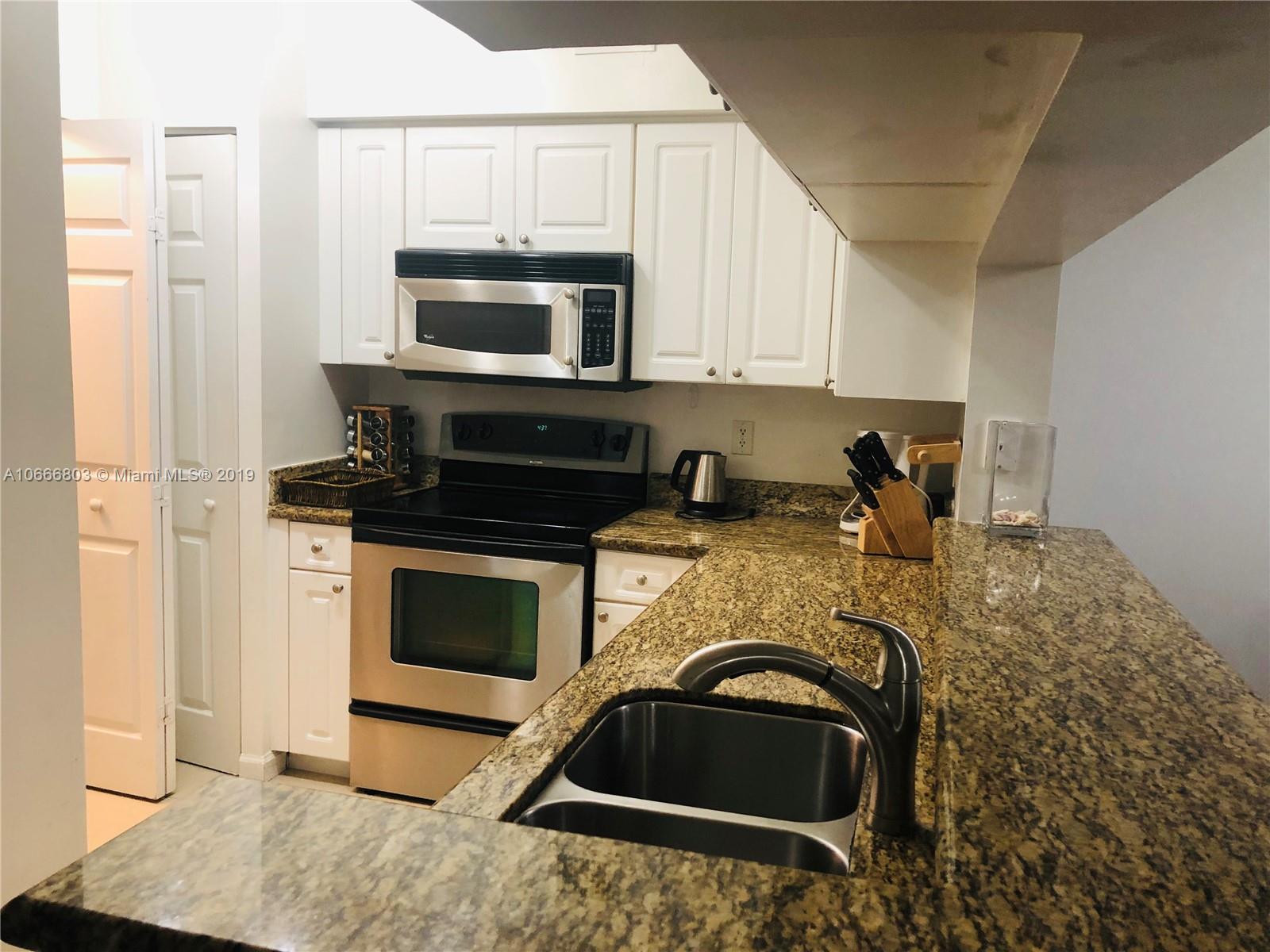 17100 North Bay Road, Unit 1212 Sunny Isles Beach, FL 33160 - Photo 12 of 24 a kitchen with a stove and a sink