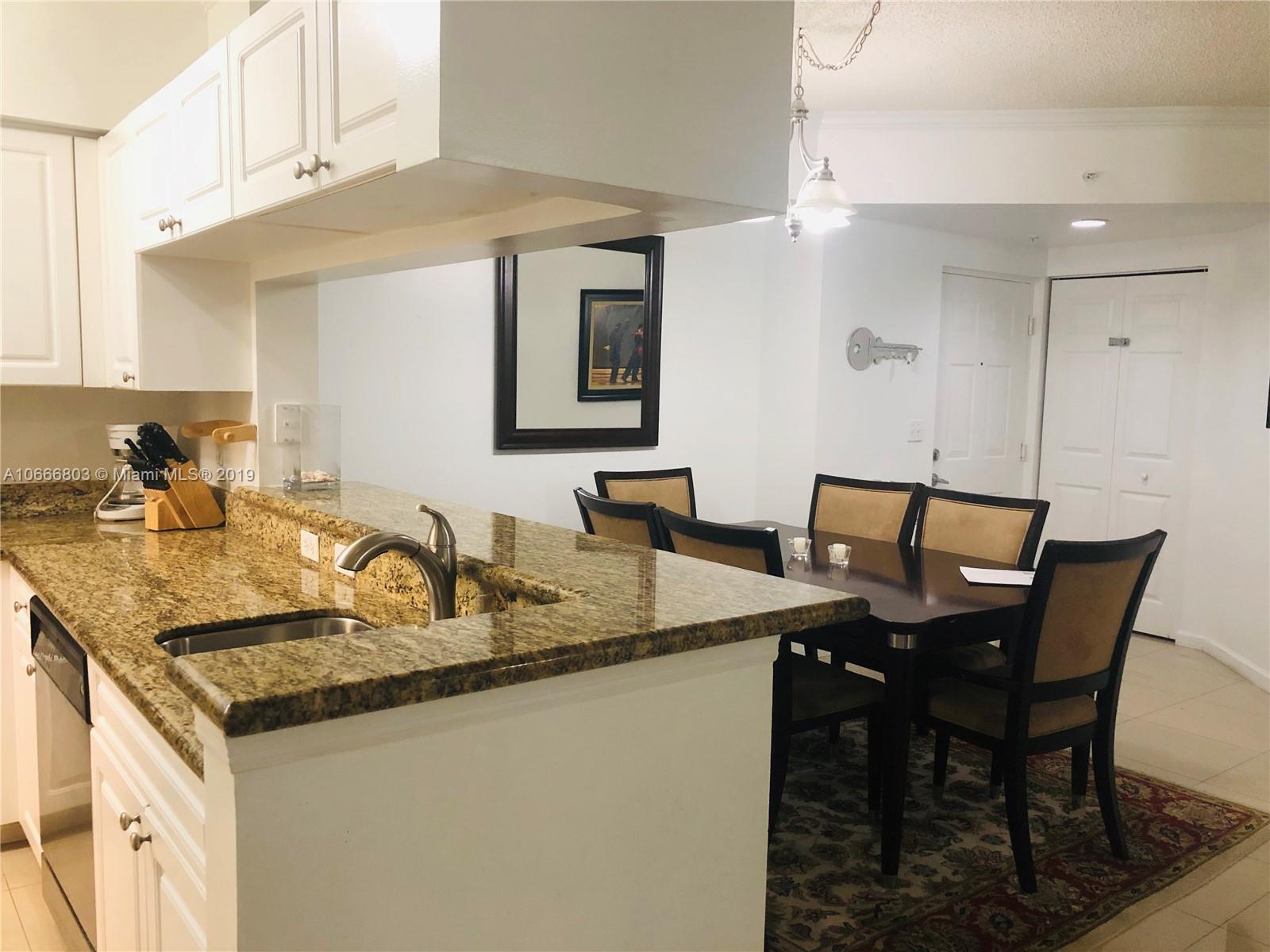 17100 North Bay Road, Unit 1212 Sunny Isles Beach, FL 33160 - Photo 14 of 24 a kitchen with granite countertop a table chairs a sink and cabinets