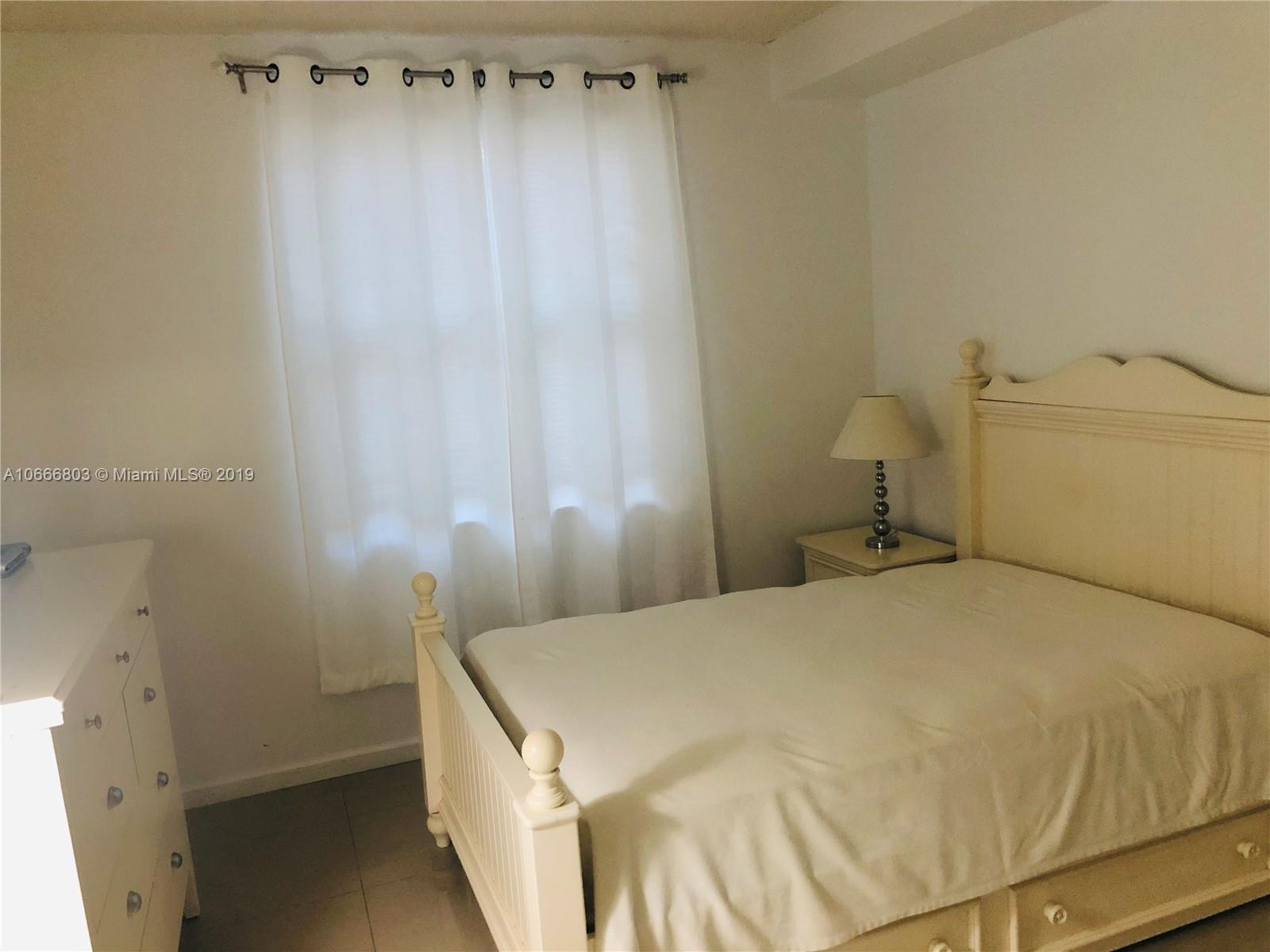 17100 North Bay Road, Unit 1212 Sunny Isles Beach, FL 33160 - Photo 18 of 24 a bedroom with a bed and a curtain