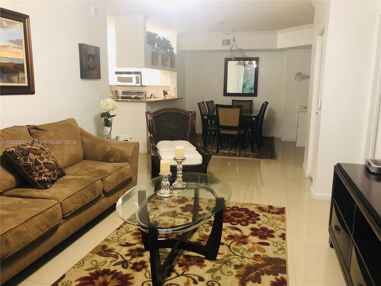 17100 North Bay Road, Unit 1212 Sunny Isles Beach, FL 33160 - Photo 2 of 24 a living room with furniture and a flat screen tv