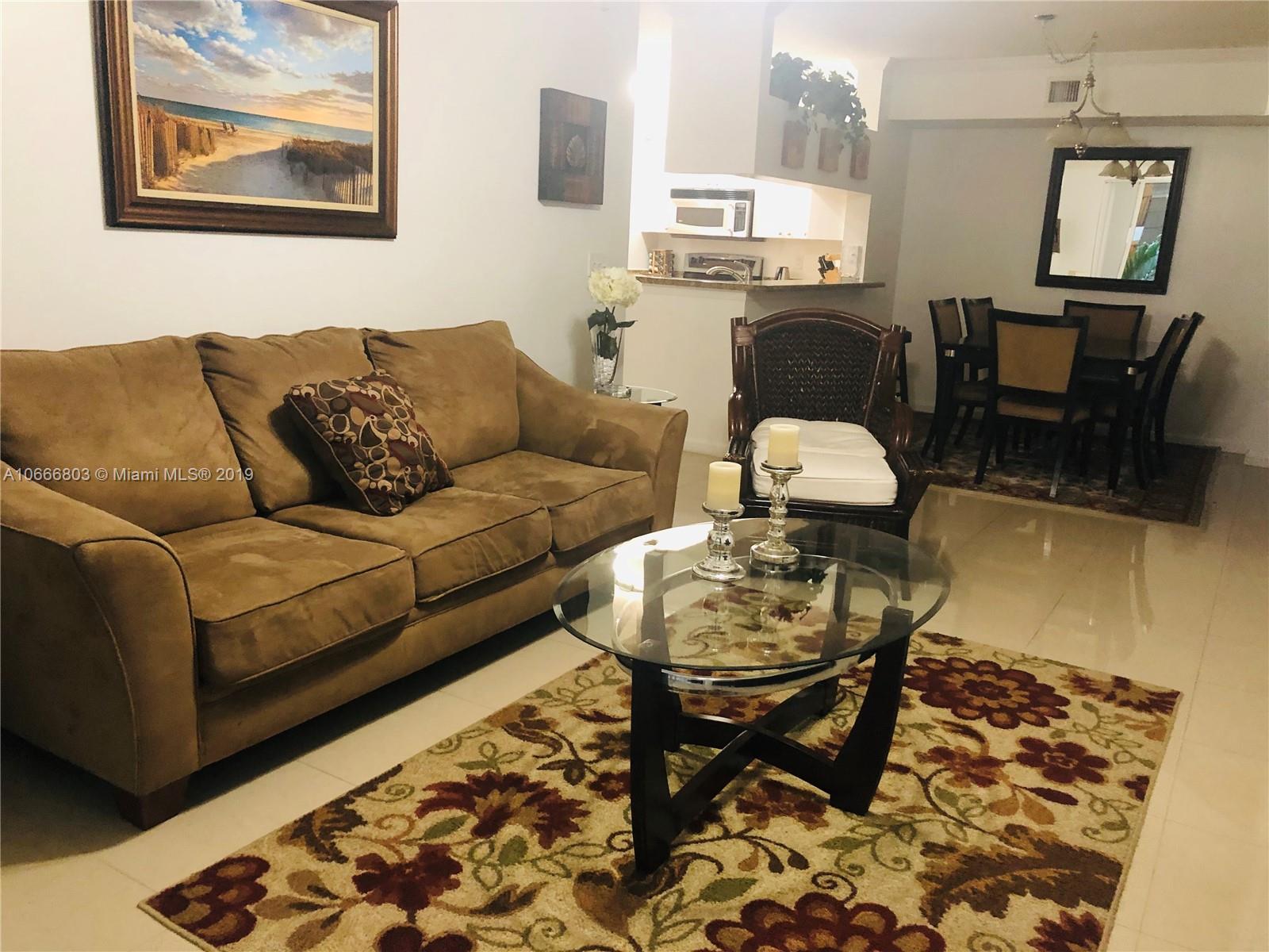 17100 North Bay Road, Unit 1212 Sunny Isles Beach, FL 33160 - Photo 7 of 24 a living room with furniture and a dining table