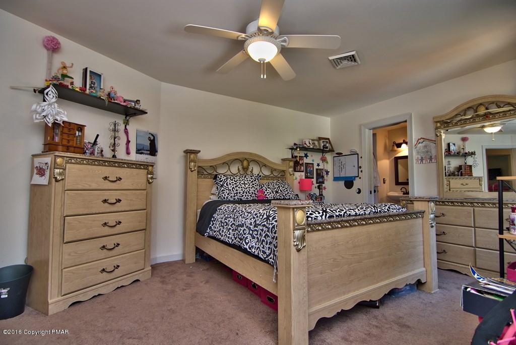 271 Williams Road Cresco, PA 18326 - Photo 25 of 46 a bedroom with a bed a dresser and a chandelier