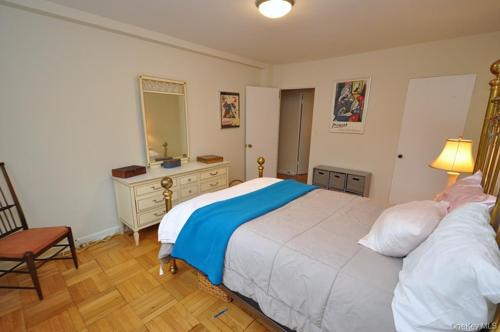 235 Garth Road, Unit A5B Scarsdale, NY 10583 - Photo 25 of 47 a bedroom with a bed and a lamp on table