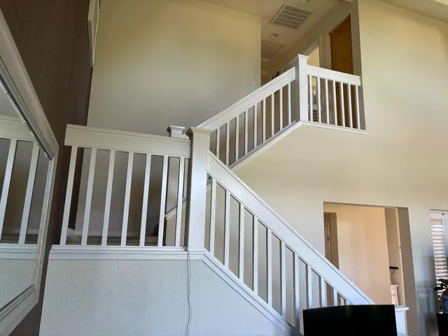 a view of staircase with railing and a window
