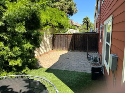 a view of a backyard with wooden fence