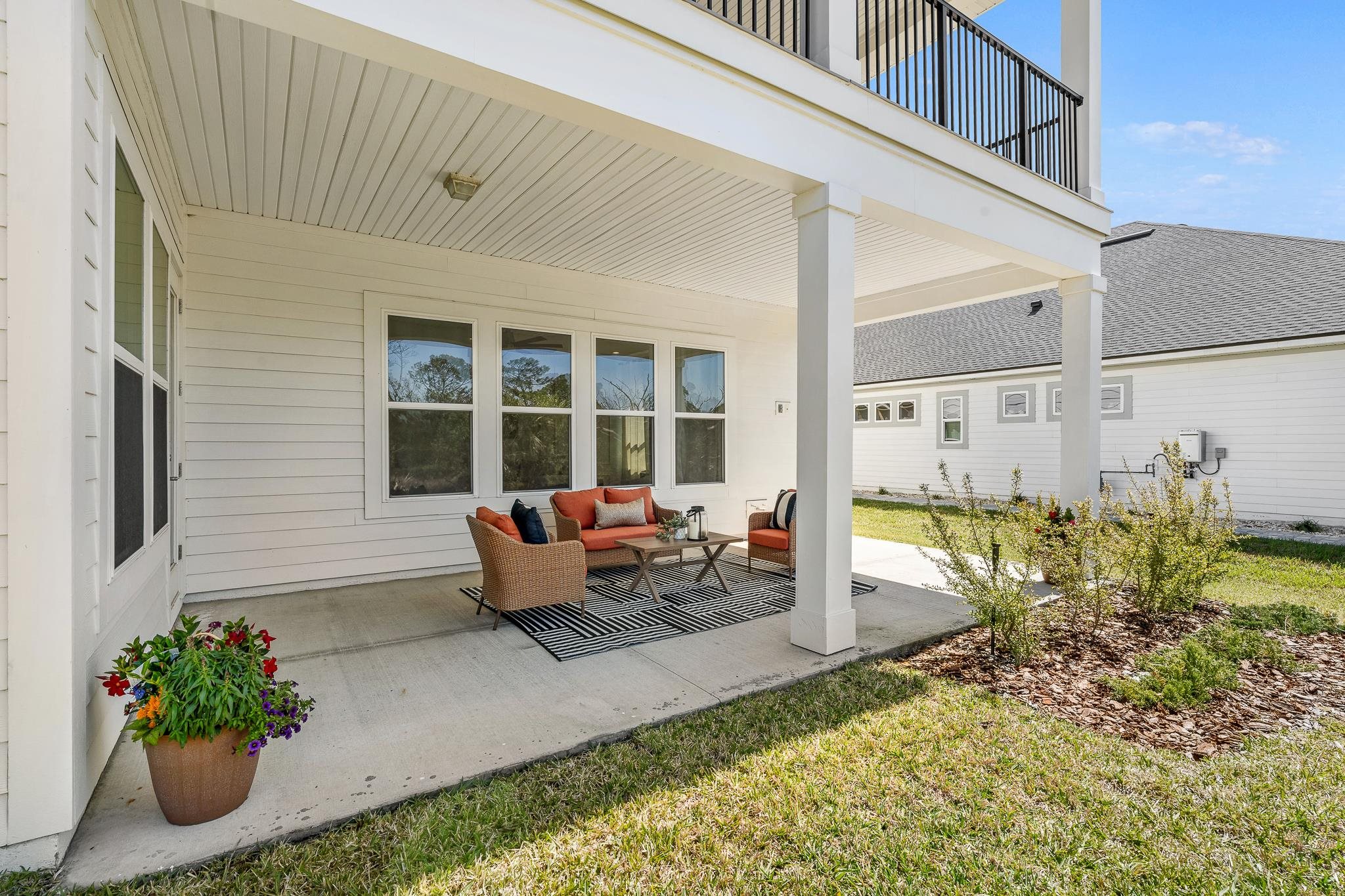 164 Tesoro Terrace St. Augustine, FL 32095 - Photo 66 of 98 a view of a patio with table and chairs potted plants with wooden fence