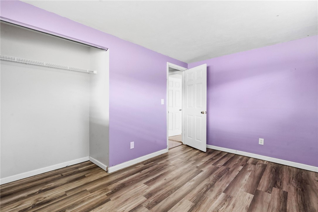 3890 Endover Road Dayton, OH 45439 - Photo 23 of 26 This spacious bedroom features warm wood flooring and a convenient open closet, offering both style and functionality.