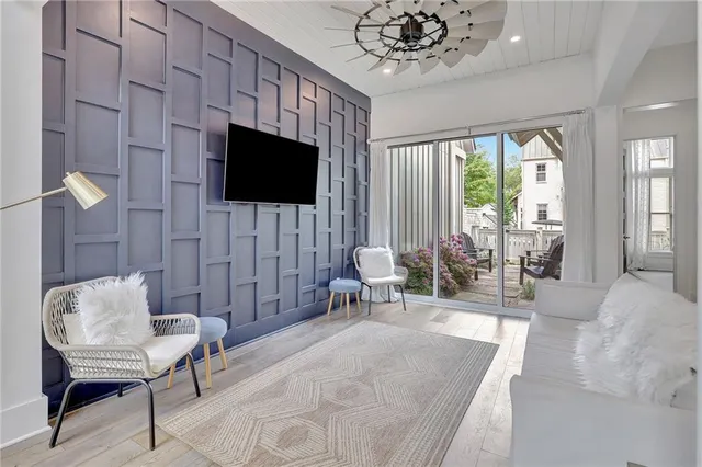 a living room with furniture a flat screen tv and a large window