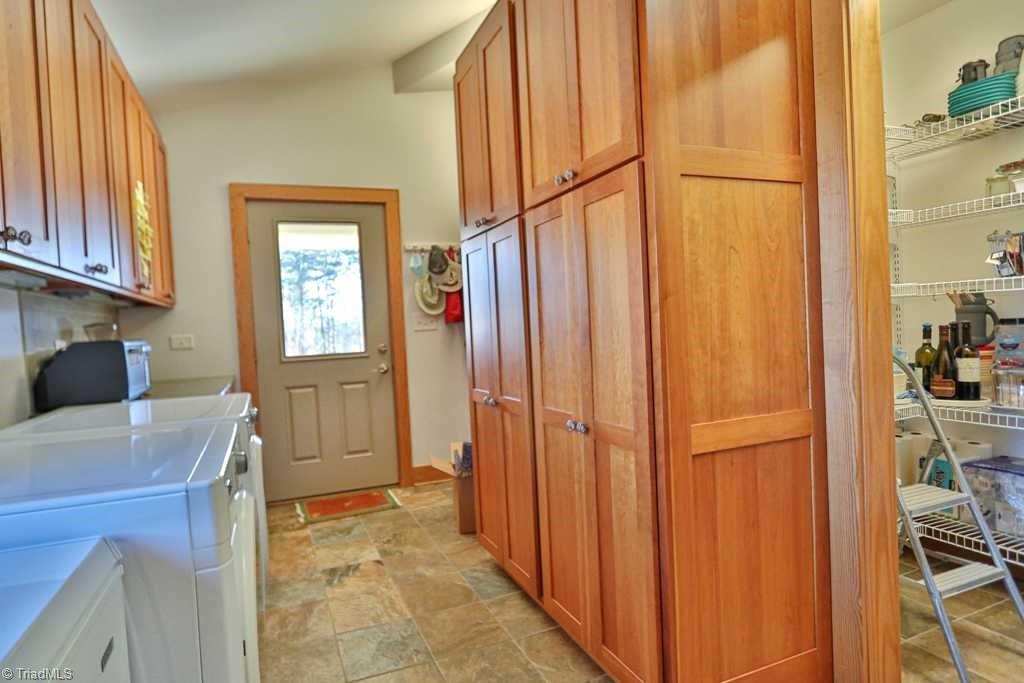 1045 West Old Phillips Road Pinnacle, NC 27043 - Photo 11 of 29 Walk in pantry on the right, lots of built in storage and counters.