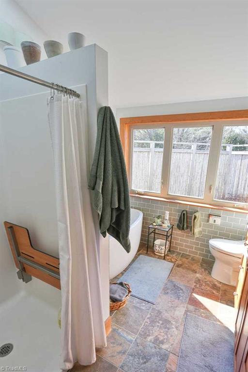 1045 West Old Phillips Road Pinnacle, NC 27043 - Photo 16 of 29 Master Bath features low threshold shower with pull down seat, soaking tub and bidet.