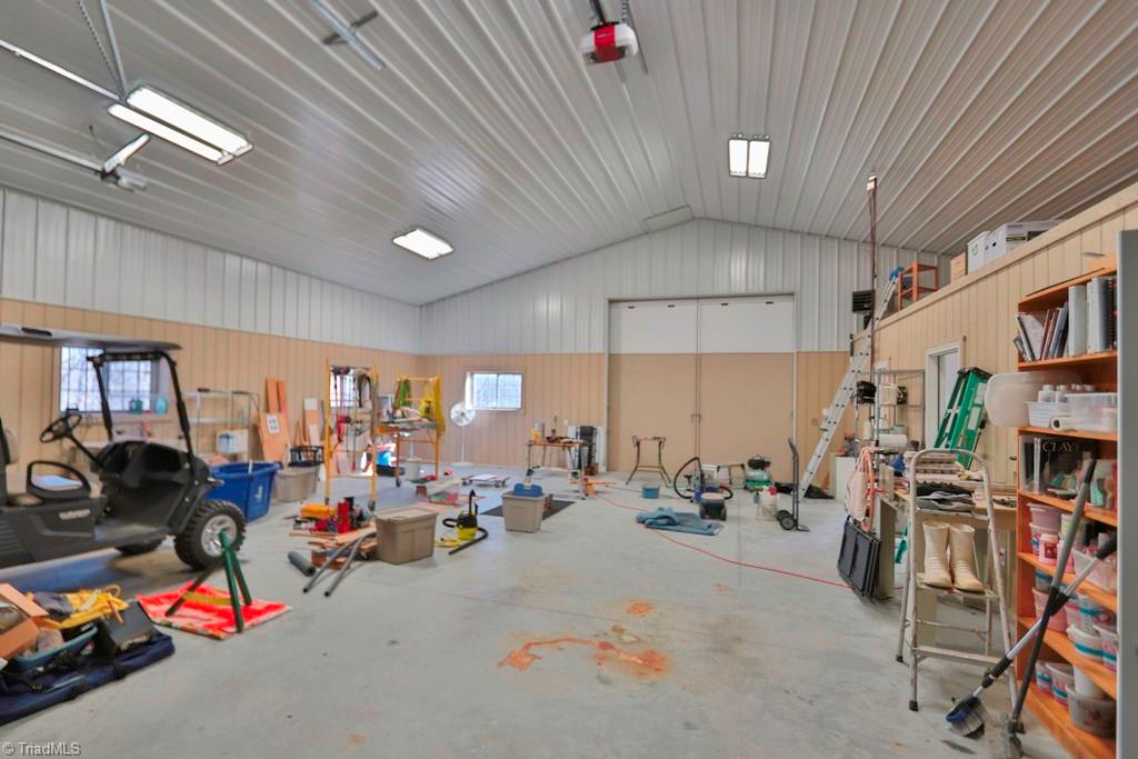 1045 West Old Phillips Road Pinnacle, NC 27043 - Photo 22 of 29 interior of barn: Main area has electric heater / no air conditioning. The two roll up doors (10 and 14 ft) are electronically controlled. The space between ceiling and roof is filled with blown insulation.