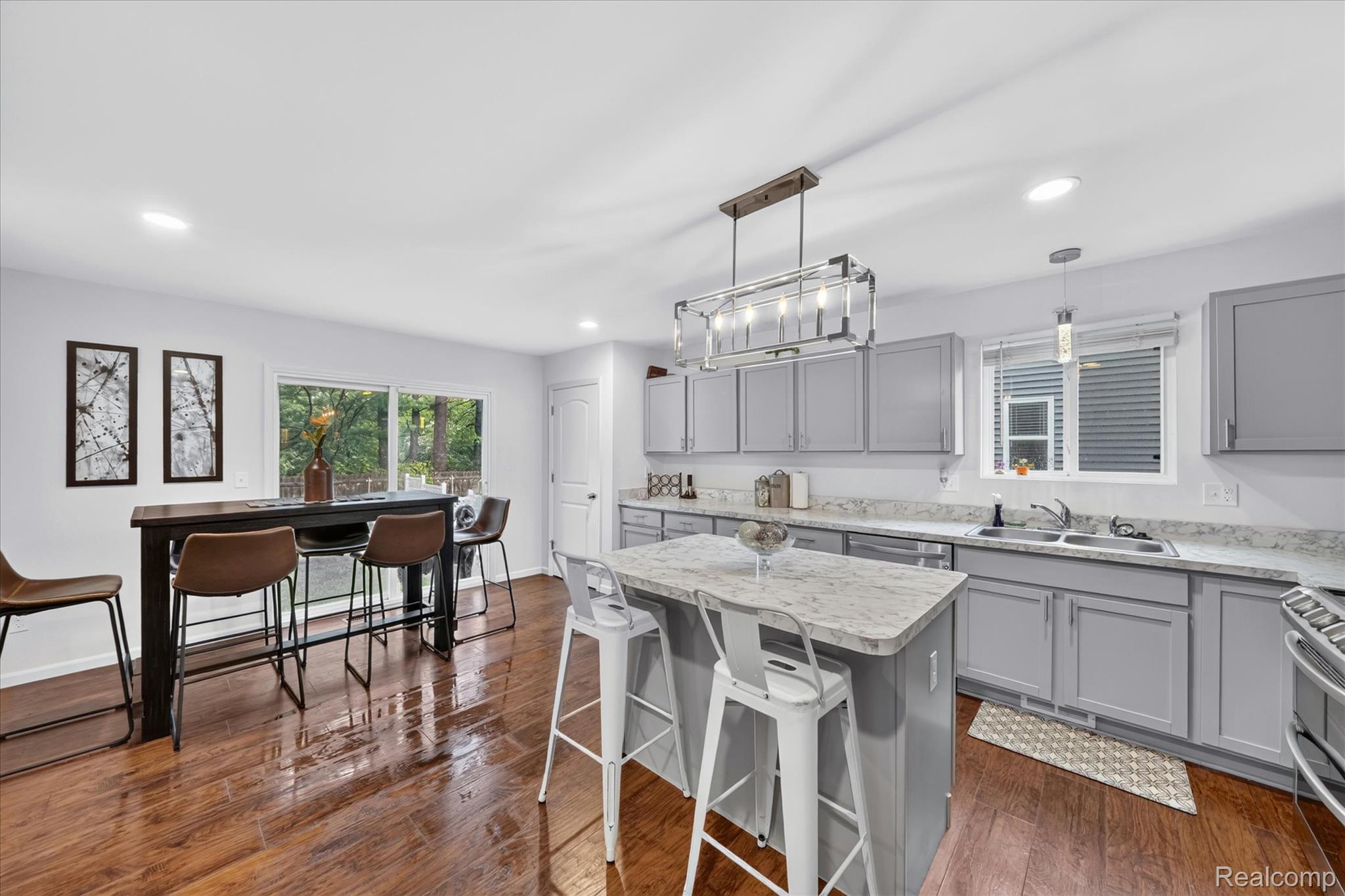 5382 Rural Terrace Waterford, MI 48329 - Photo 14 of 35 Kitchen featuring a center island, grey cabinetry, white countertops, wood-finish flooring, and a sliding glass door